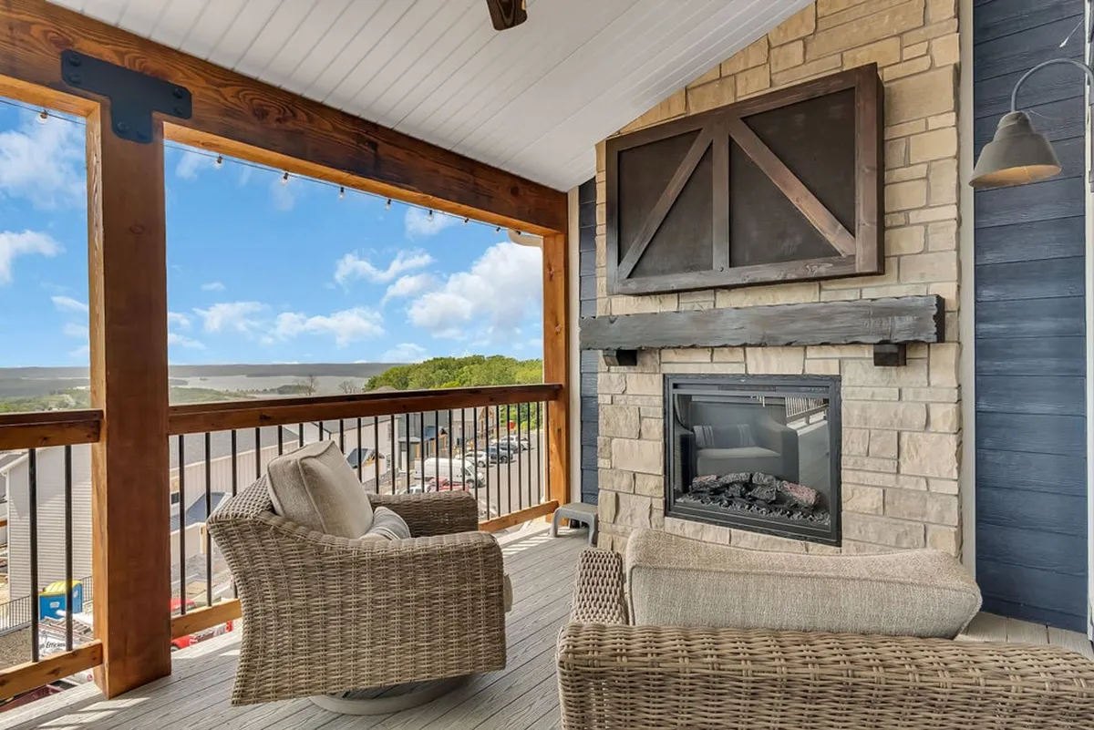 An inviting exterior seating area with a cozy fireplace, comfortable chairs, and a scenic view of the surrounding landscape. The space is designed for relaxation and conversation, with the tranquil outdoors visible in the background, reinforcing a sense of retreat and luxury.