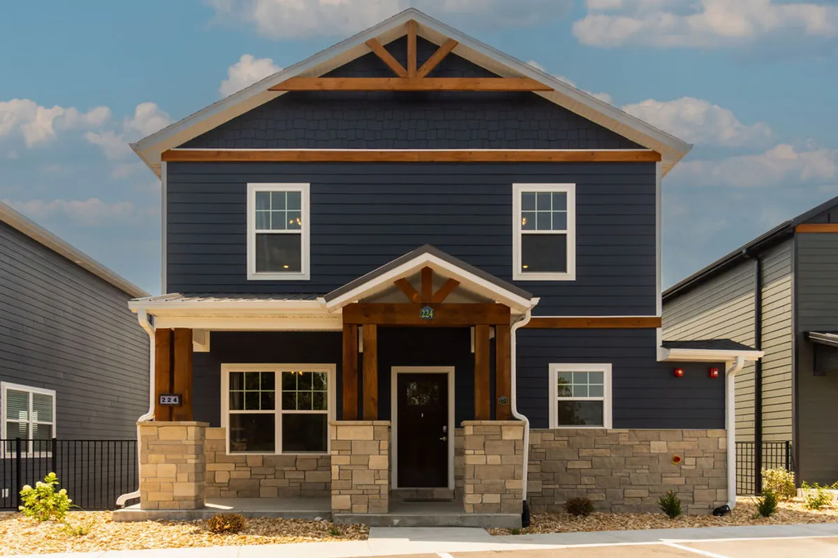 This image presents the welcoming front entrance of the Lakehouse Lodge, showcasing inviting stone and wood details along with large windows that let in natural light. The design conveys a sense of arrival and sets the stage for group gatherings and celebrations.